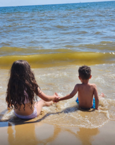Two children on a beach engraved into a silver pendant